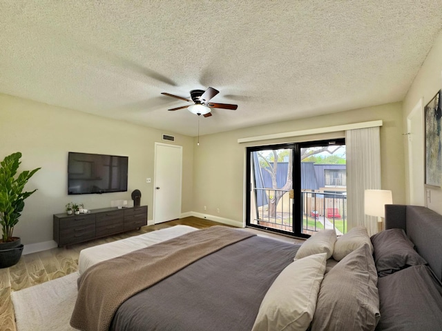 bedroom with access to exterior, visible vents, a ceiling fan, wood finished floors, and baseboards