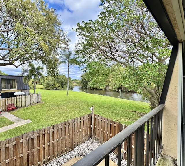 view of yard featuring a water view and a fenced backyard