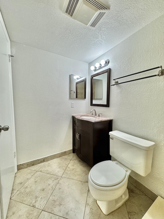 bathroom featuring baseboards, visible vents, a textured wall, a textured ceiling, and vanity