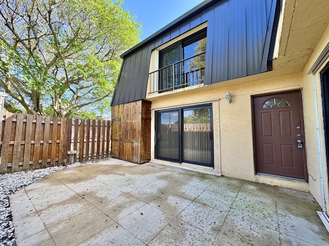 exterior space with a patio area, fence, and stucco siding