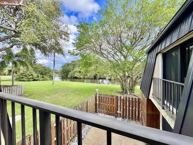 exterior space with a water view, a lawn, and fence