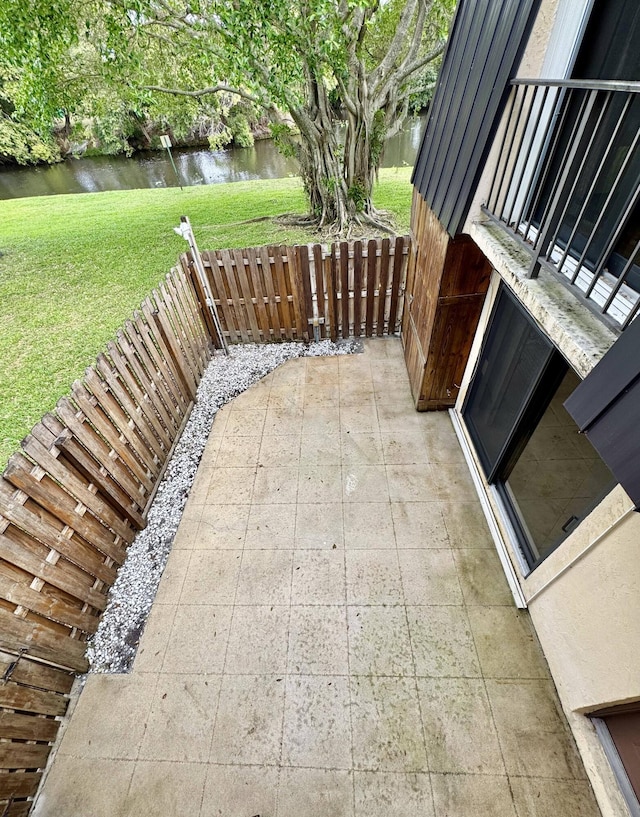 view of patio with a water view and a fenced backyard