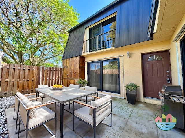 view of patio featuring outdoor dining area, fence, and grilling area