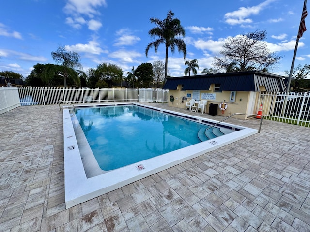 community pool with fence and a patio