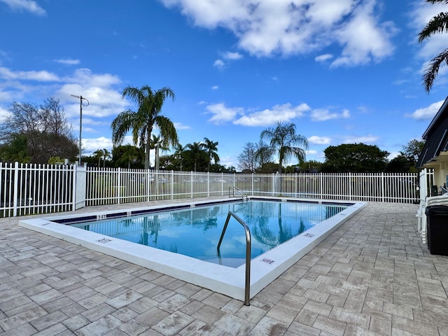 pool with a patio and fence