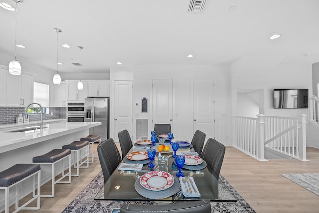 dining space featuring sink and light wood-type flooring