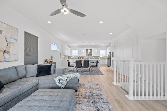 living room with ceiling fan, a healthy amount of sunlight, and light wood-type flooring