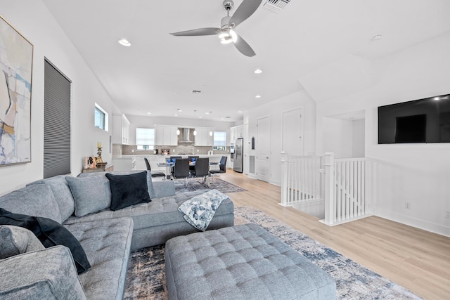 living room featuring ceiling fan and light wood-type flooring