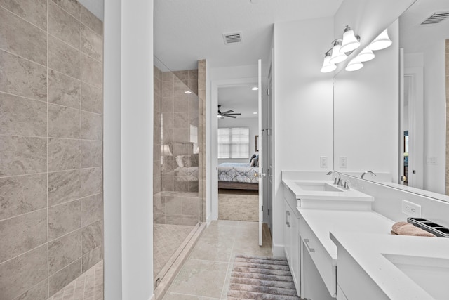 bathroom with ceiling fan, tile patterned floors, vanity, and a tile shower