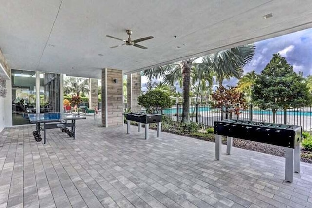 view of patio with a community pool and ceiling fan