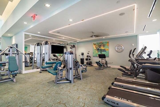 workout area with light colored carpet and a raised ceiling