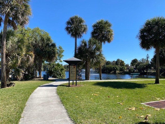 view of home's community with a water view and a lawn