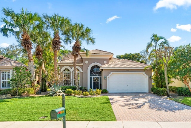 mediterranean / spanish-style home featuring a garage and a front lawn