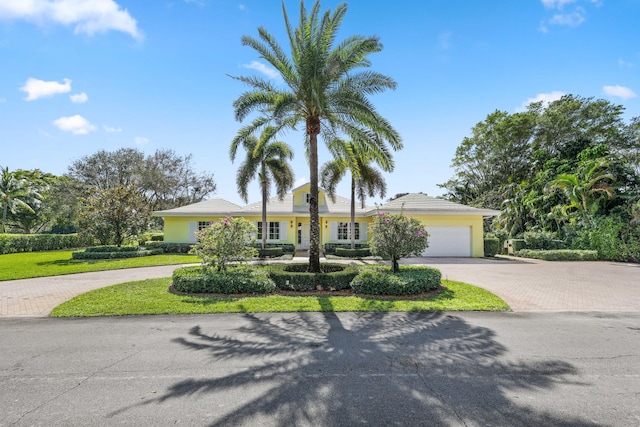 single story home featuring a front lawn and a garage