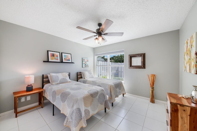 bedroom featuring ceiling fan, a textured ceiling, and light tile patterned floors