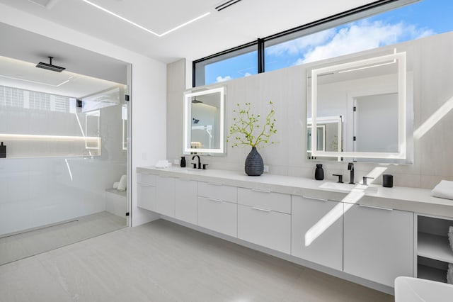 bathroom with tasteful backsplash, vanity, and a tile shower