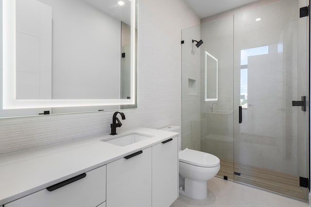 bathroom featuring vanity, toilet, tile walls, a stall shower, and backsplash