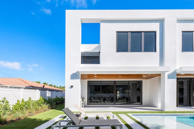 back of property with a fenced in pool, wine cooler, and a patio area