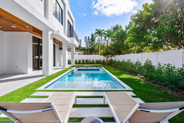 view of swimming pool featuring a patio area and a lawn