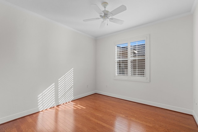 unfurnished room with crown molding, wood-type flooring, and baseboards