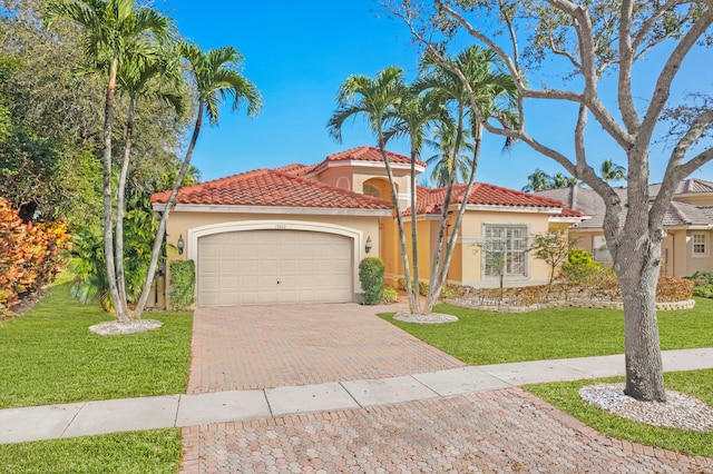 mediterranean / spanish-style house featuring a garage, a tile roof, decorative driveway, stucco siding, and a front yard