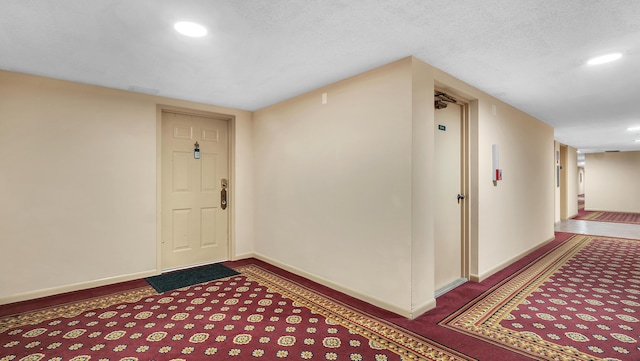 entryway with carpet flooring and a textured ceiling