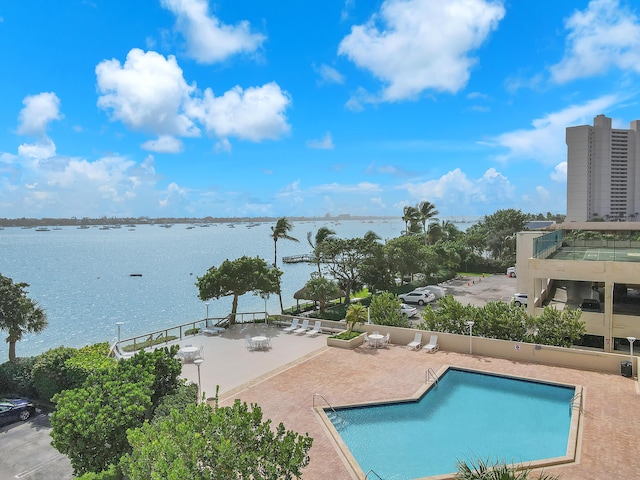 view of pool featuring a water view and a patio area