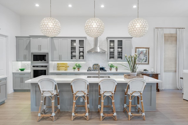 kitchen featuring pendant lighting, an island with sink, and appliances with stainless steel finishes