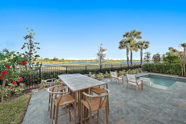 view of patio / terrace featuring a fenced in pool and a water view