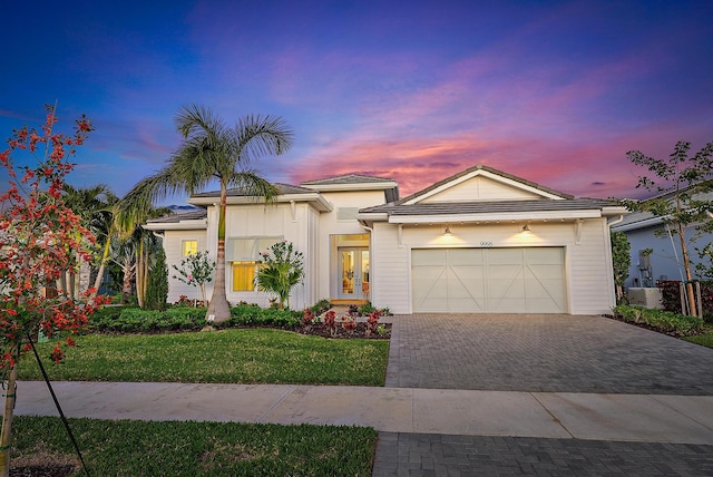 view of front of property with a garage and a yard