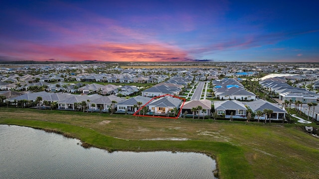 aerial view at dusk featuring a water view