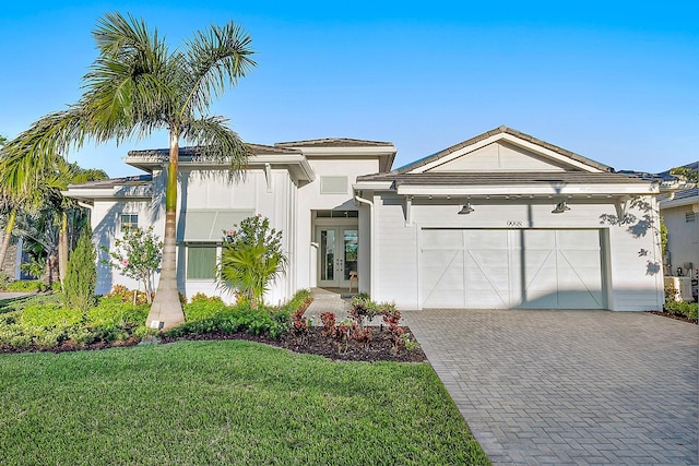 view of front of home featuring a garage, a front yard, and french doors