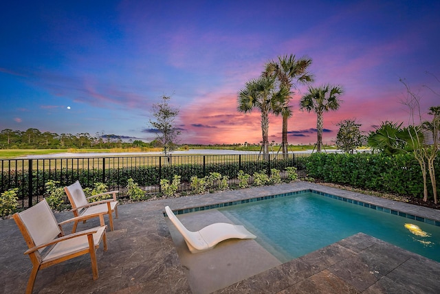 pool at dusk with a patio