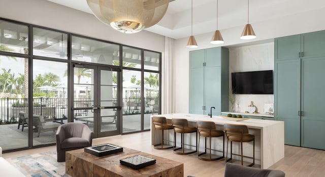 interior space featuring hanging light fixtures, green cabinets, and light hardwood / wood-style flooring