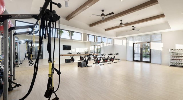 gym with light hardwood / wood-style flooring and a high ceiling