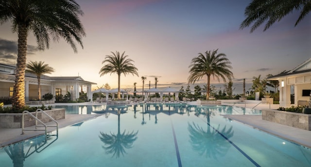 pool at dusk with a patio area