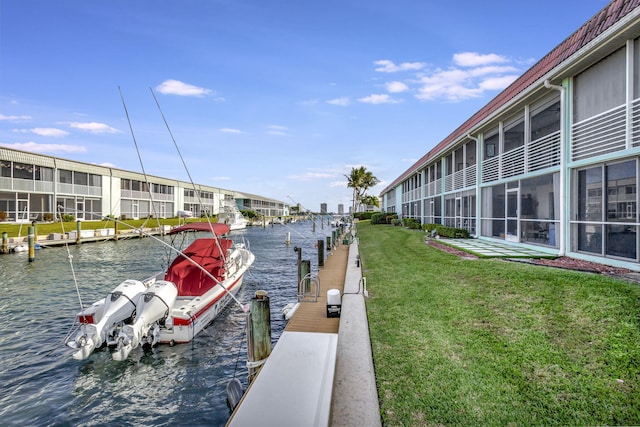 view of dock featuring a lawn and a water view