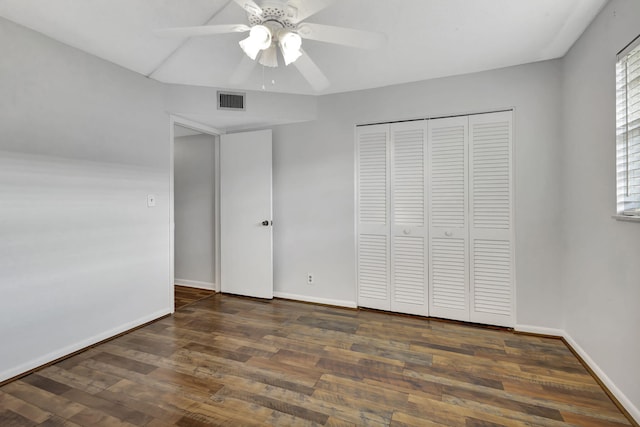 unfurnished bedroom featuring dark wood-type flooring, a closet, and ceiling fan