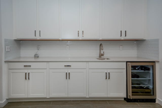 bar with wine cooler, wood finish floors, a sink, and tasteful backsplash