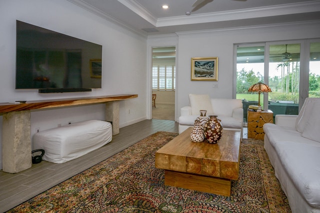 living area featuring ceiling fan, recessed lighting, wood finished floors, ornamental molding, and a raised ceiling