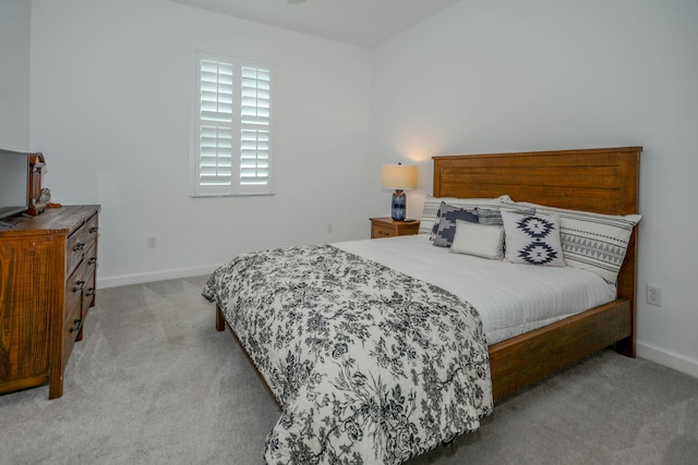 bedroom with light colored carpet and baseboards