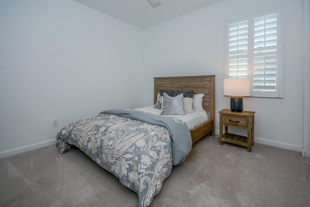 bedroom featuring light carpet and baseboards