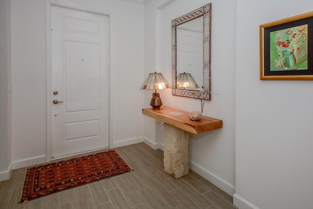 doorway to outside featuring baseboards and wood tiled floor