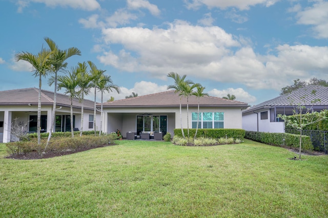 rear view of house featuring a ceiling fan, a lawn, an outdoor living space, and stucco siding