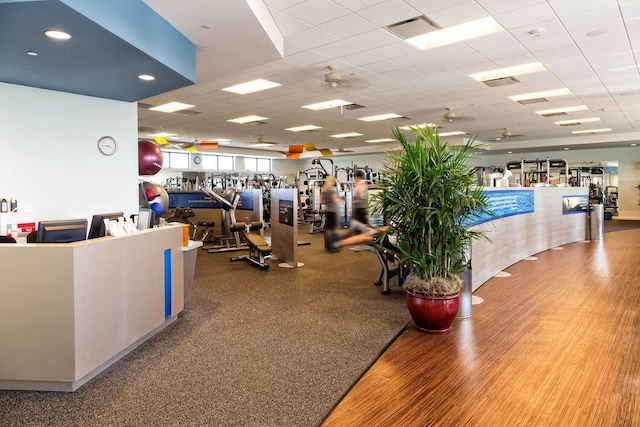 gym featuring a paneled ceiling and visible vents