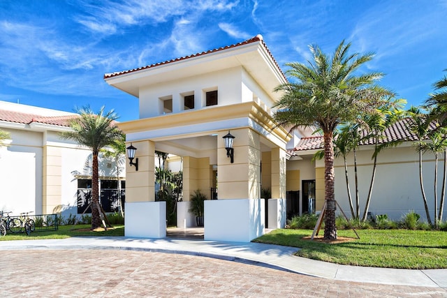 mediterranean / spanish house featuring a tile roof and stucco siding