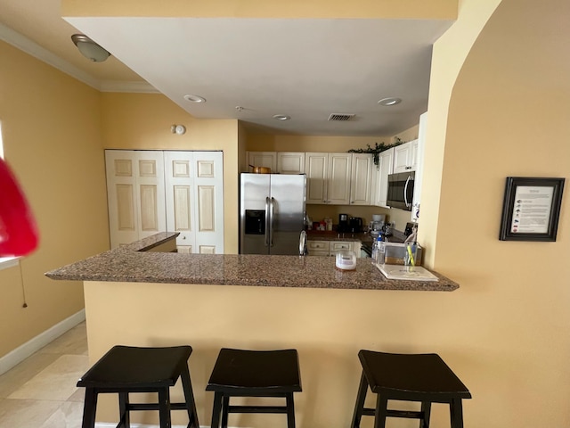 663 Hibiscus St, West Palm Beach, FL 33401 - kitchen with a kitchen breakfast bar, kitchen peninsula, white cabinets, and appliances with stainless steel finishes