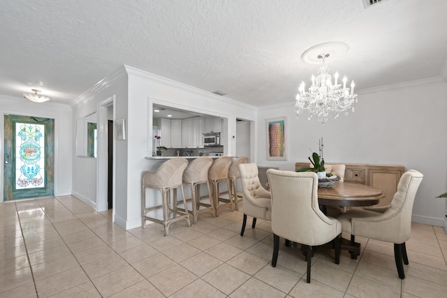 tiled dining room with an inviting chandelier, ornamental molding, and a textured ceiling