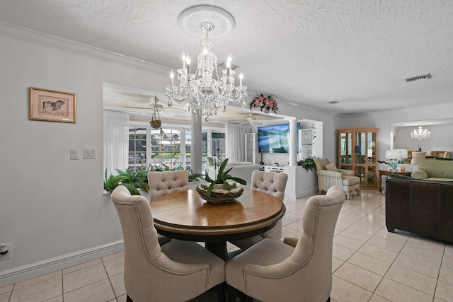 dining room featuring light tile patterned flooring, ornamental molding, a chandelier, and a textured ceiling