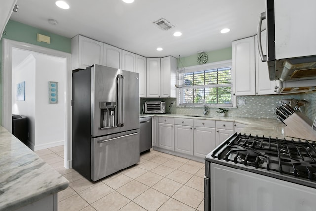 kitchen with stainless steel appliances, sink, and white cabinets